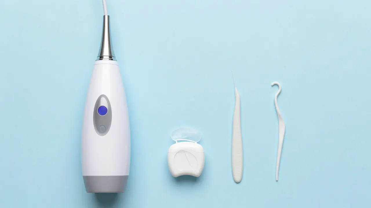 Sada pro komplexní péči o zuby zahrnující ultrasonický čistič, nit a stěrka na jazyk.